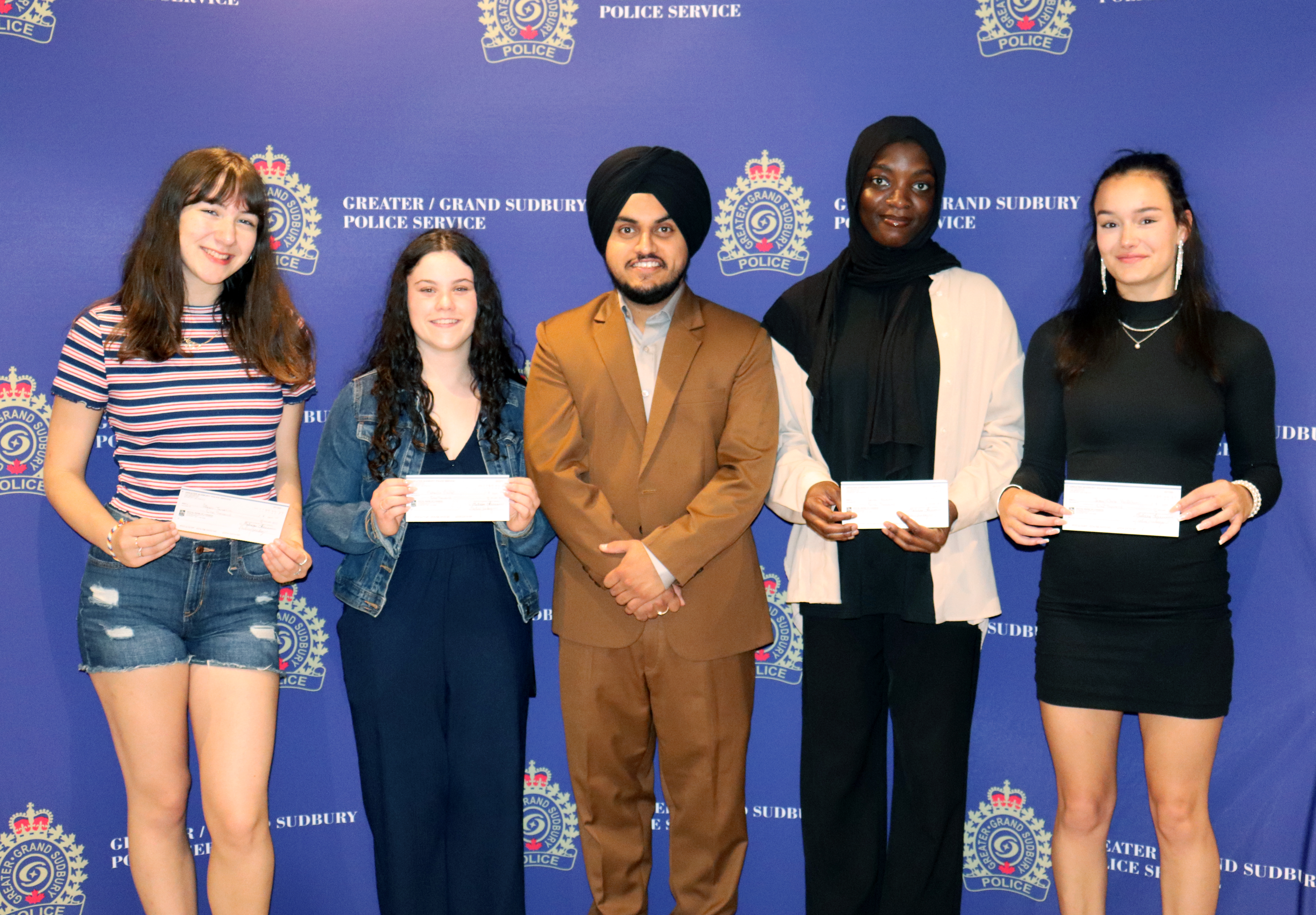 group of people standing holding cheques