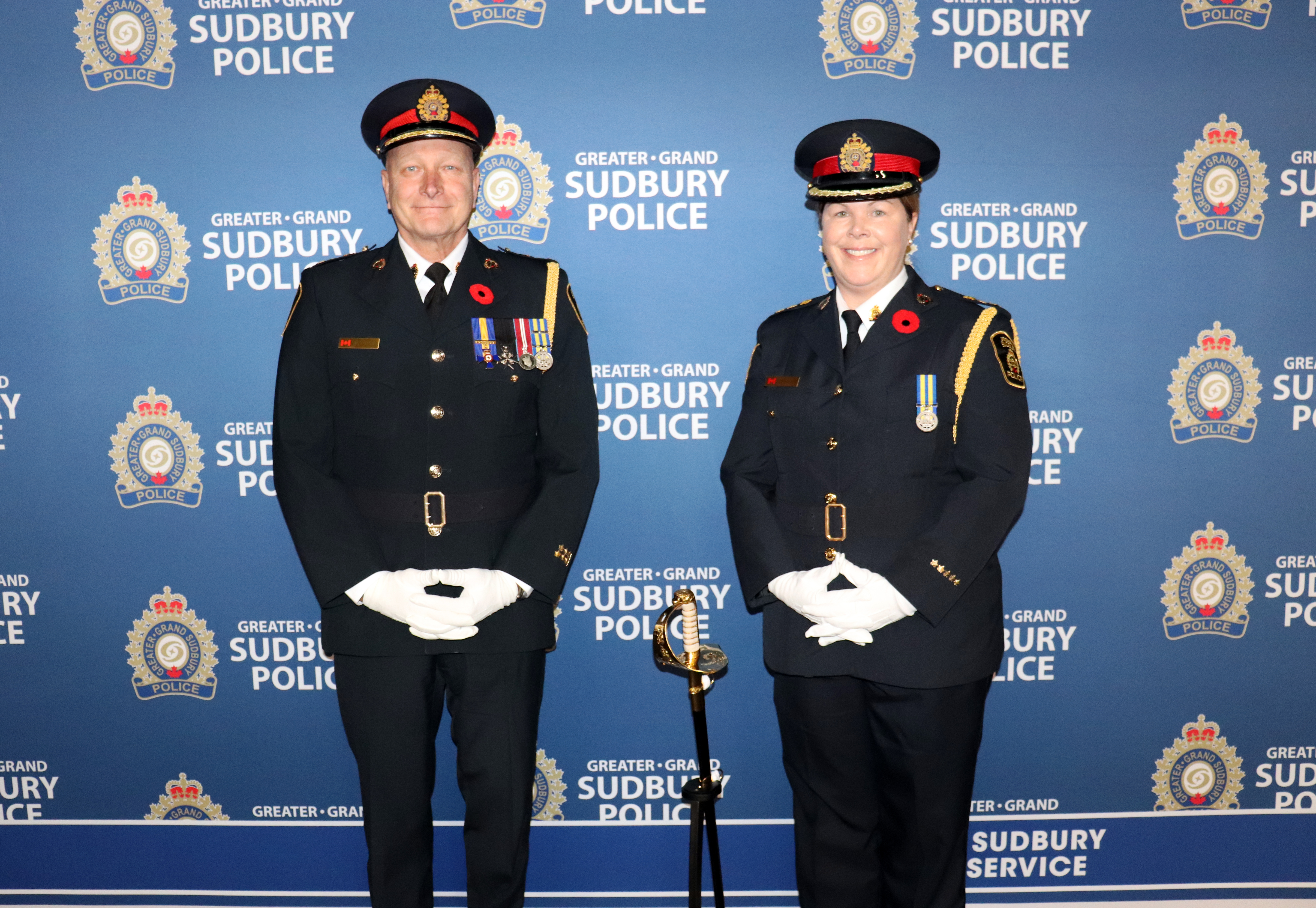 two police officers in uniform with sword in between