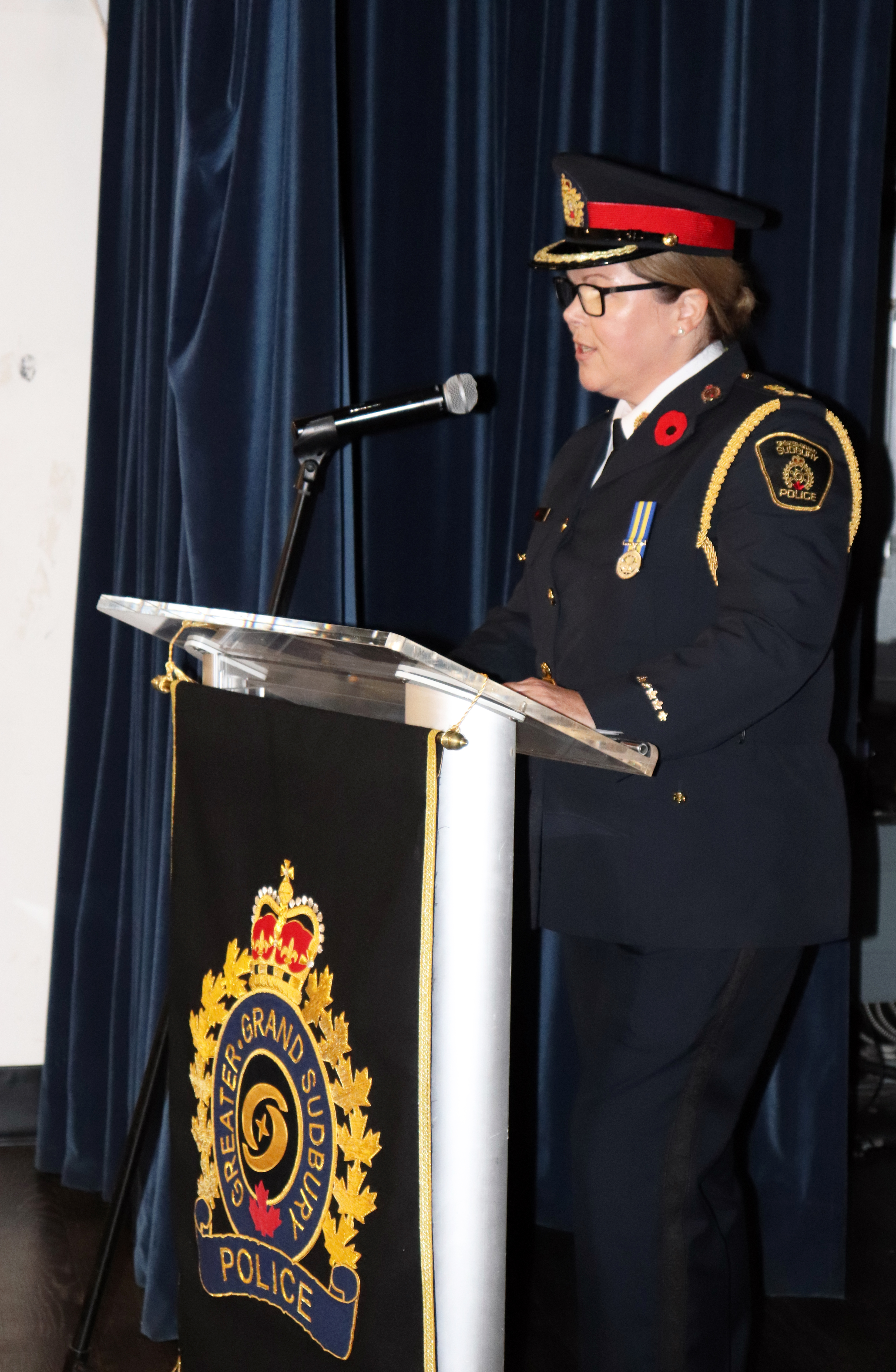 woman in police uniform speaking at podium