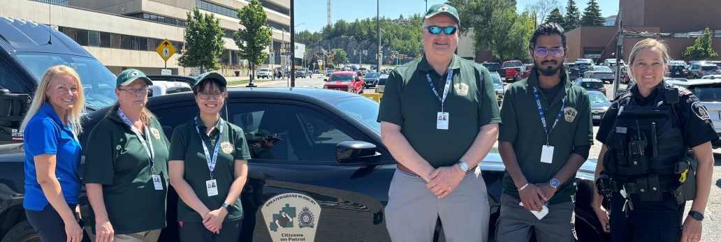 COPs volunteers and police officer standing next to vehicle