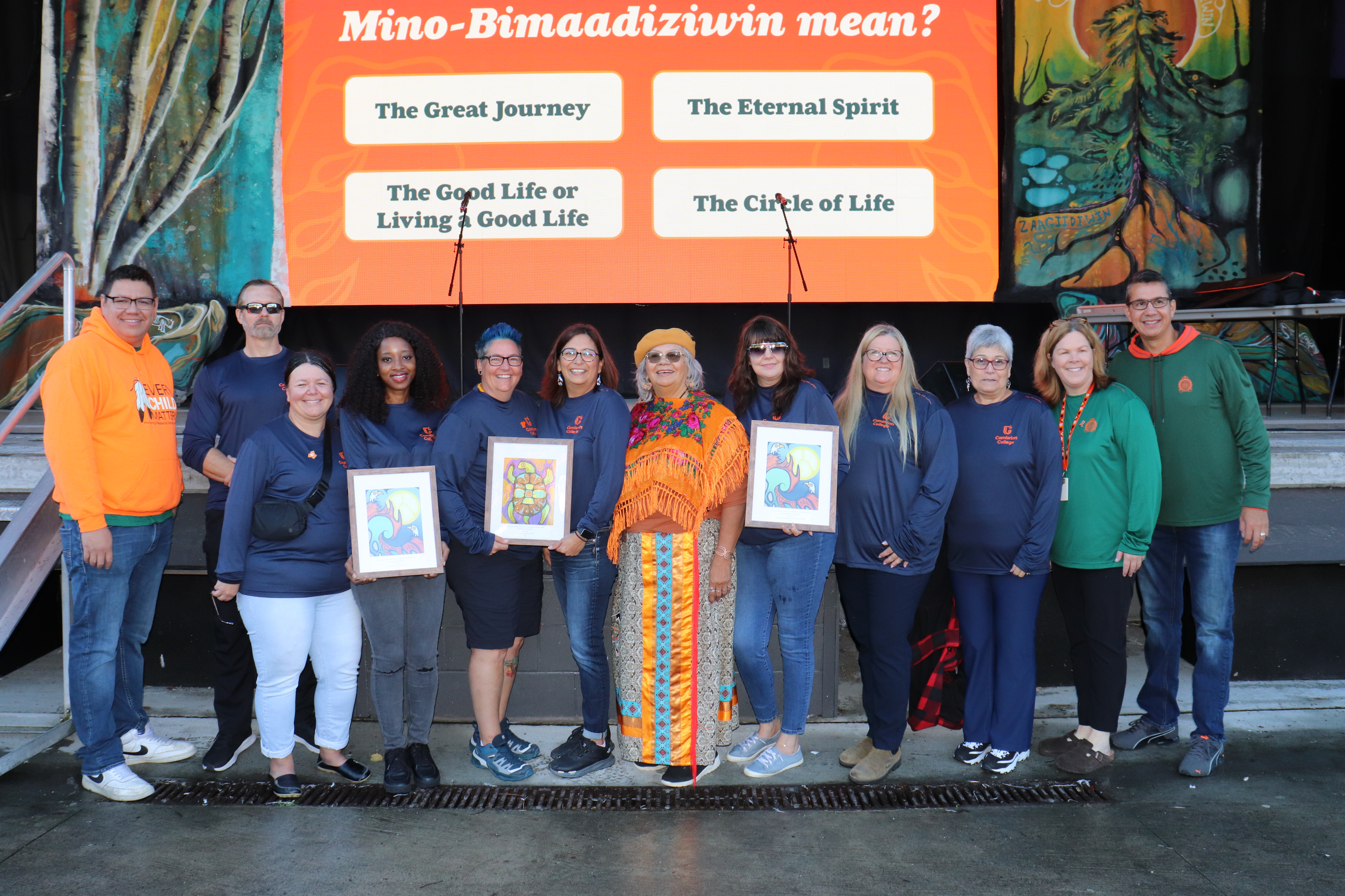 group of people standing outside wearing orange